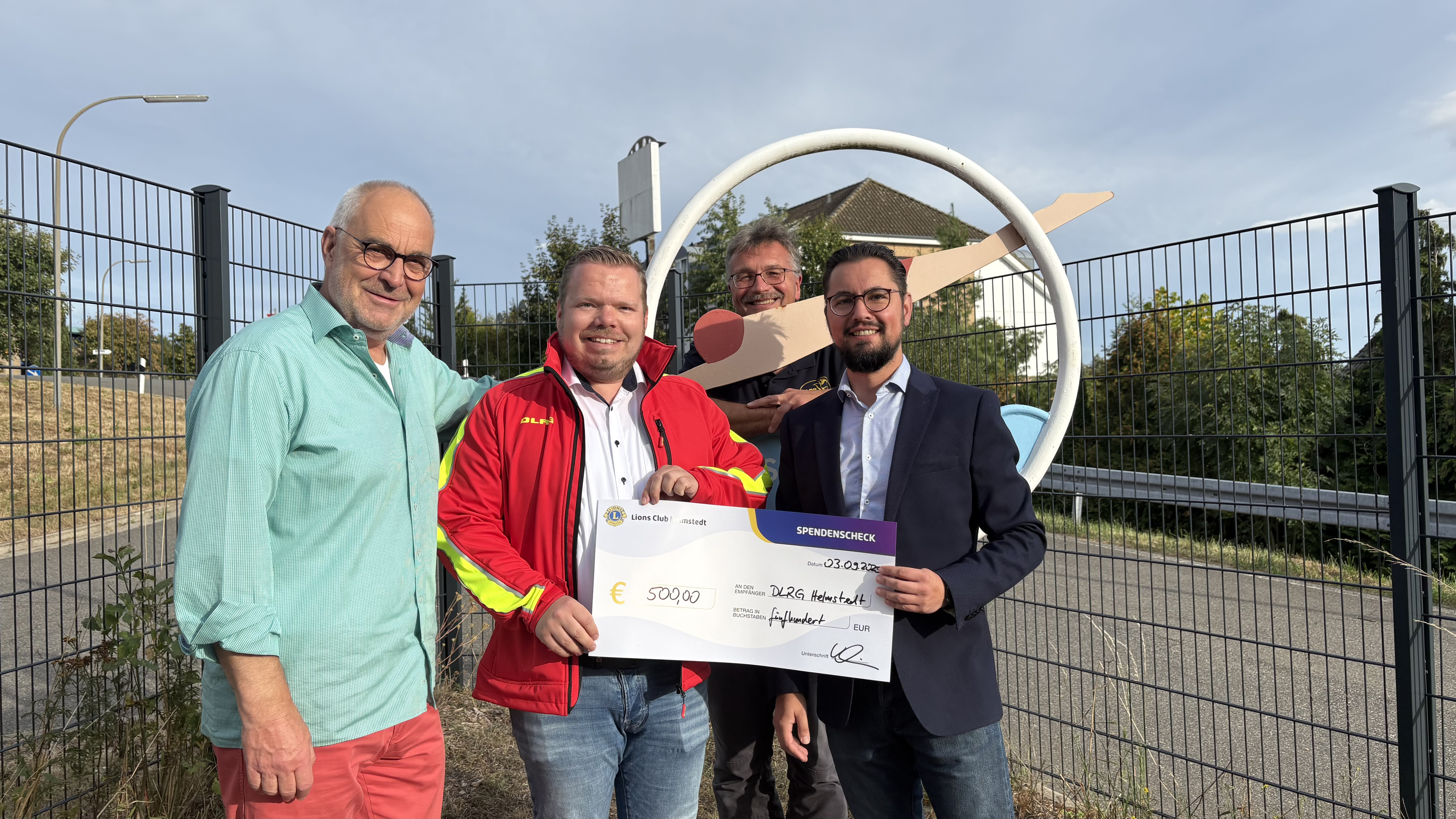 Martin Lehmann (Lions Hilfswerk Helmstedt), Christian Burzlaff (Schatzmeister DLRG-Ortsgruppe Helmstedt), Rainer Ketzler (Vorsitzender DLRG-Ortsgruppe Helmstedt) und Andreas Warmbein (Präsident Lions Club Helmstedt) bei der symbolischen Scheckübergabe.